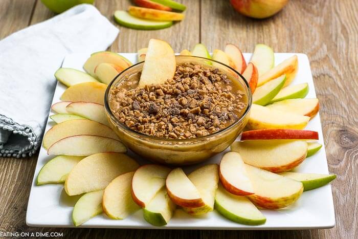 Caramel apple dip recipe is smooth and creamy with a decadent topping. Serve with apple slices, graham crackers or pretzels for the best snack. Learn how to make the best caramel dip with heath bars, cream cheese and more for an easy treat. This homemade dip with brown sugar and toffee is creamy and very simple to make. #eatingonadime #caramelappledip #caramelappledipcreamcheese #caramelappledipeasy #CreamCheeseBrownSugar #CreamCheeseToffeeBits #sauce #DIY