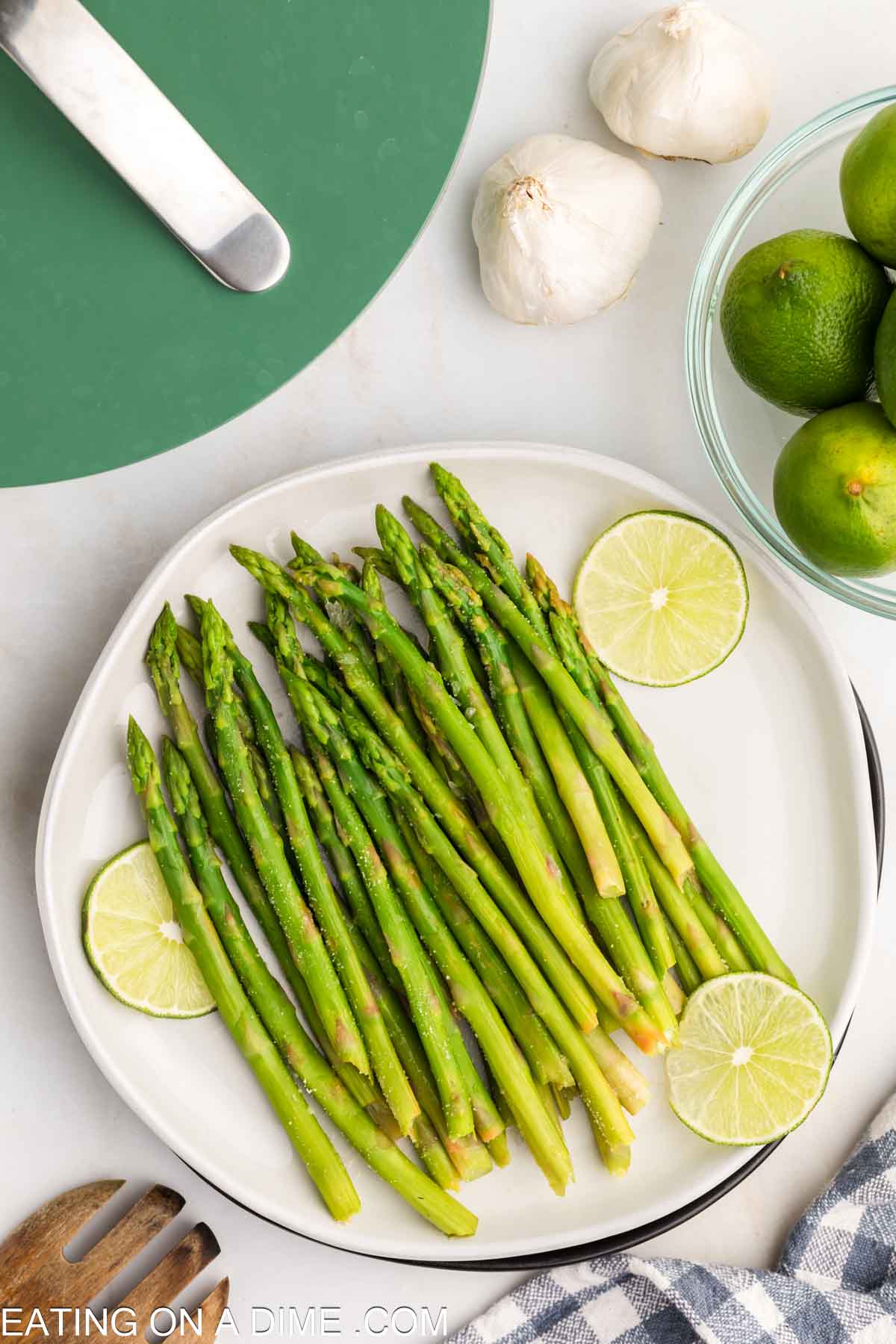 Steamed asparagus on a plate with fresh limes