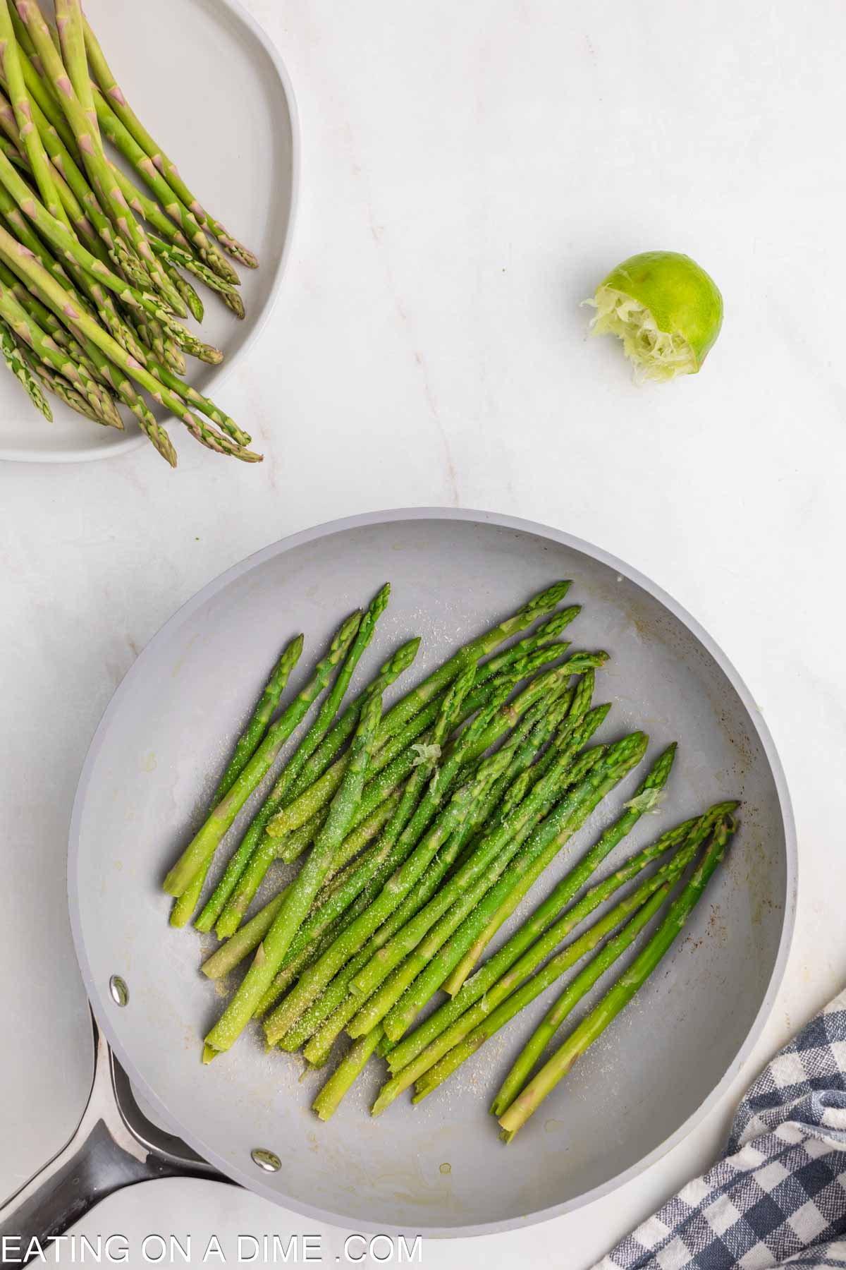 Topping the cooked asparagus with seasoning