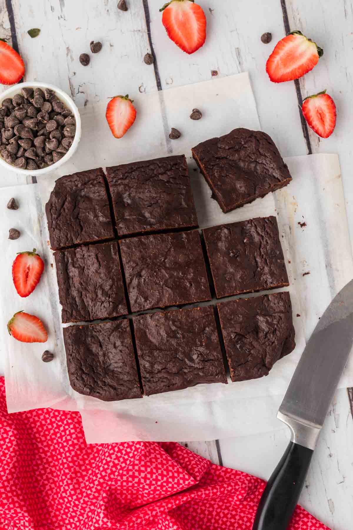 Brownies cut into squares with a bowl of chocolate chips 