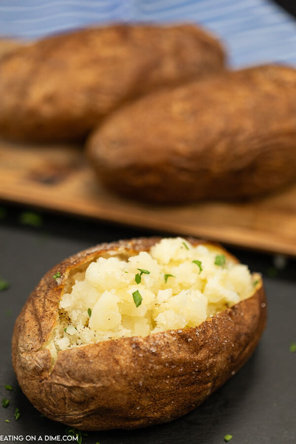 We have the best ever air fryer baked potato recipe. This is a must try and such an easy and tasty side dish for busy weeknights. Make the Best Ever baked potatoes in air fryer. Each bite is crispy on the outside and tender on the inside. This simple recipe for baked potatoes is perfect.  #eatingonadime #airfryerbakedpotatoes #airfryerbakedpotatoesrecipes #airfryerbakedpotatoestime #seasoned 