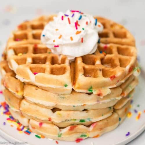 Cake Mix Waffles Stacked on a plate topped with whipped cream and sprinkles