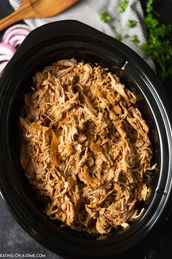 BBQ shredded pulled pork in a black crock pot 