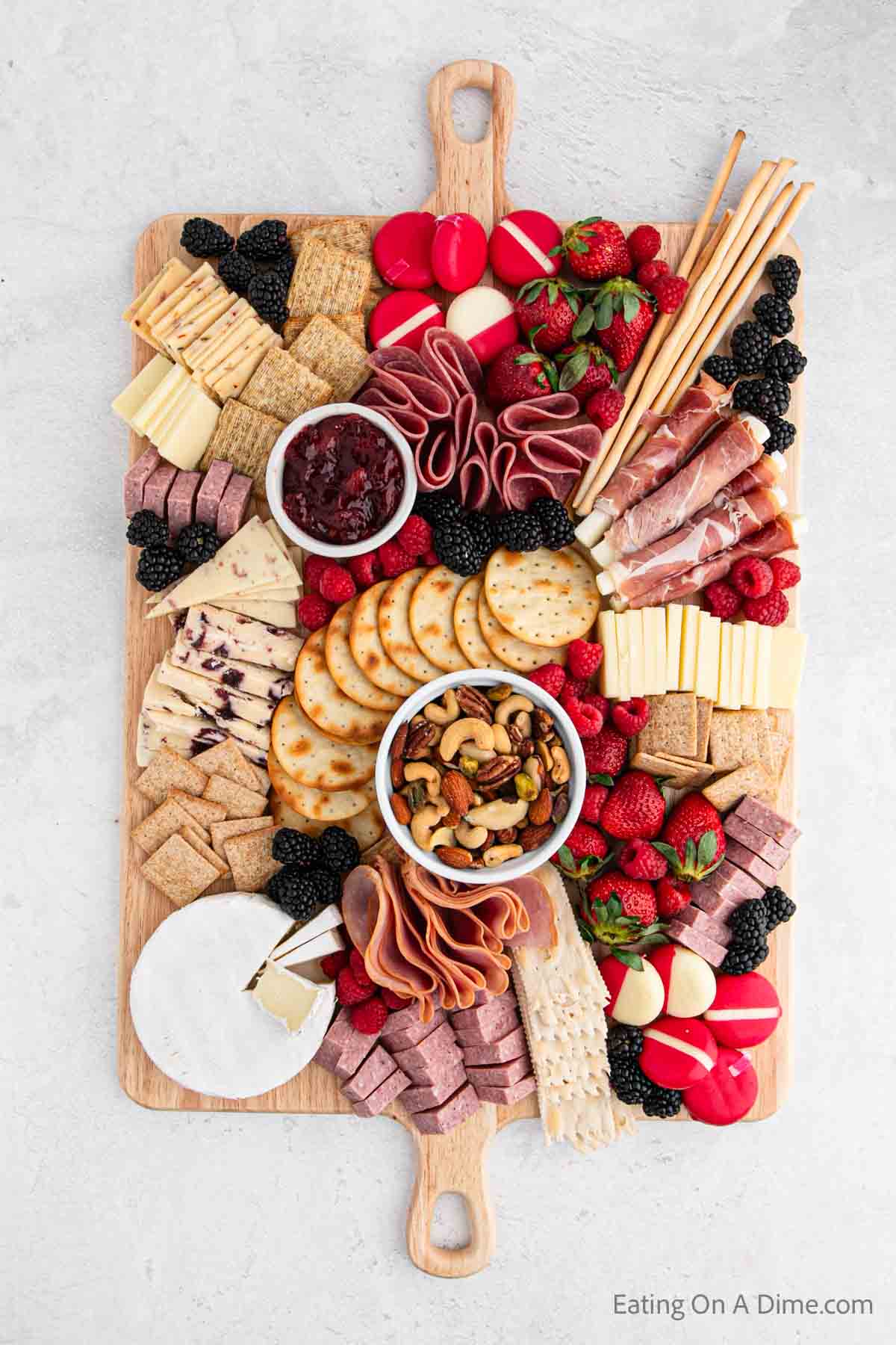 Placing nuts, crackers, cheese, meats on the board