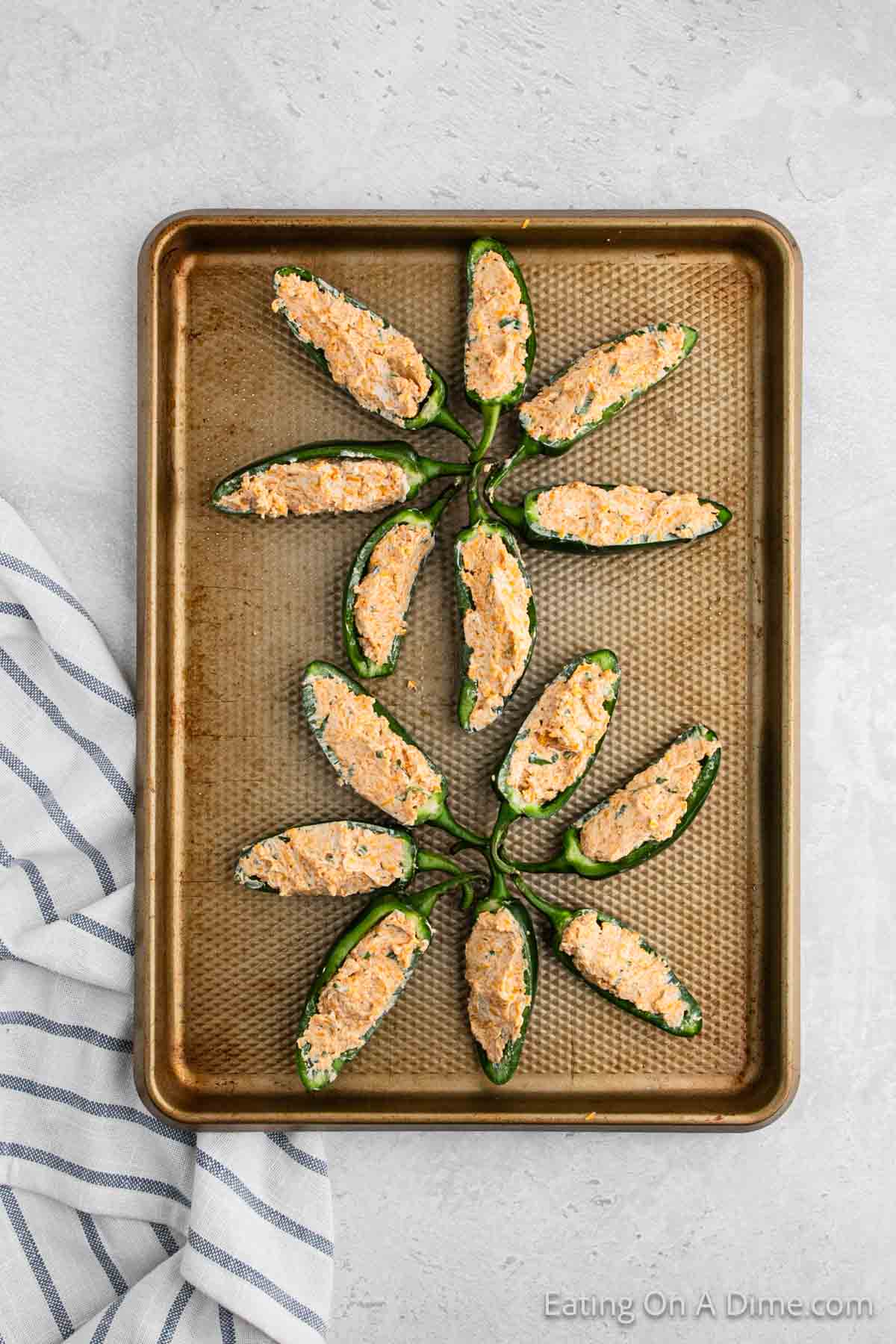 Stuffed jalapenos on a baking sheet