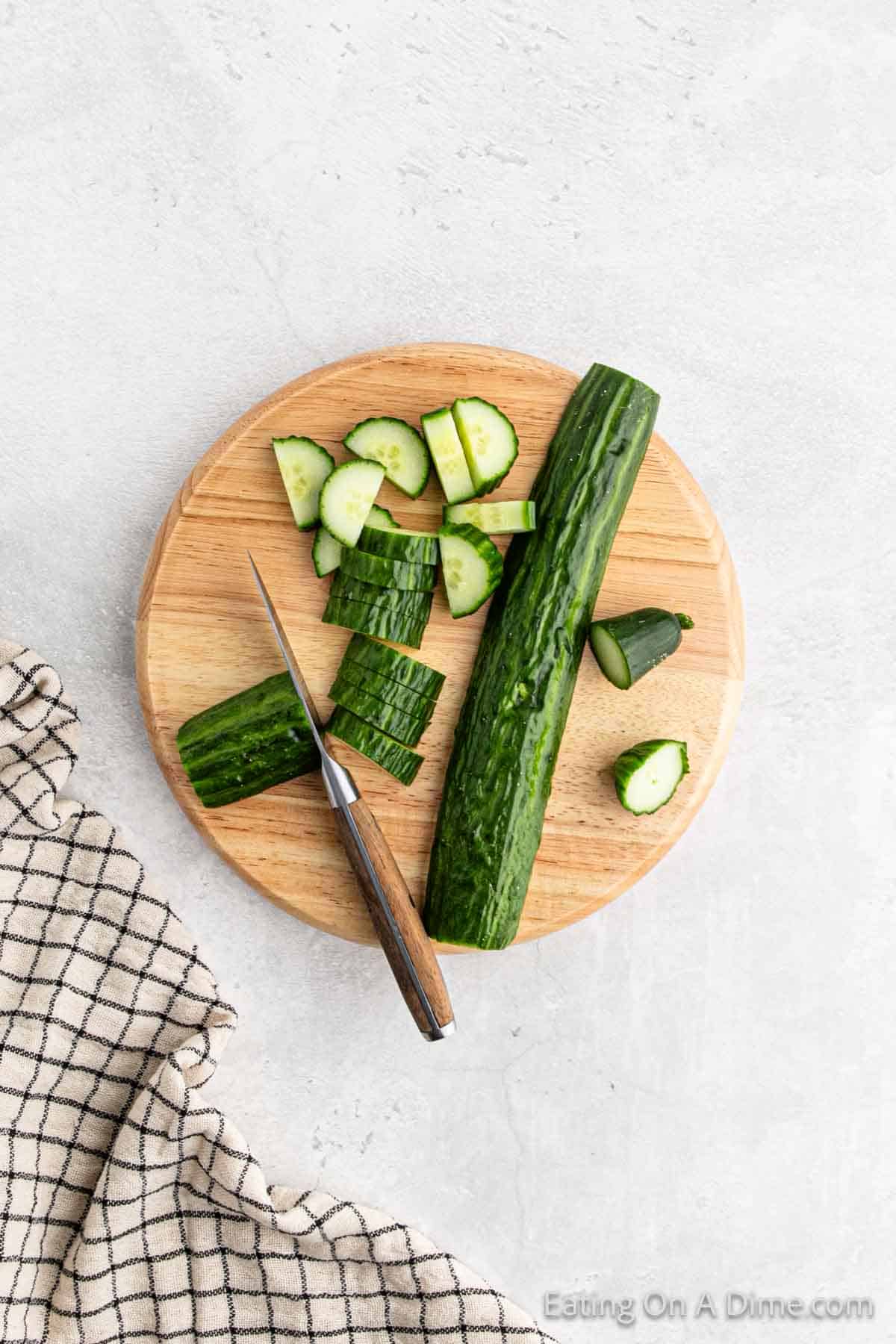 Cutting cucumber on a cutting board with a knife