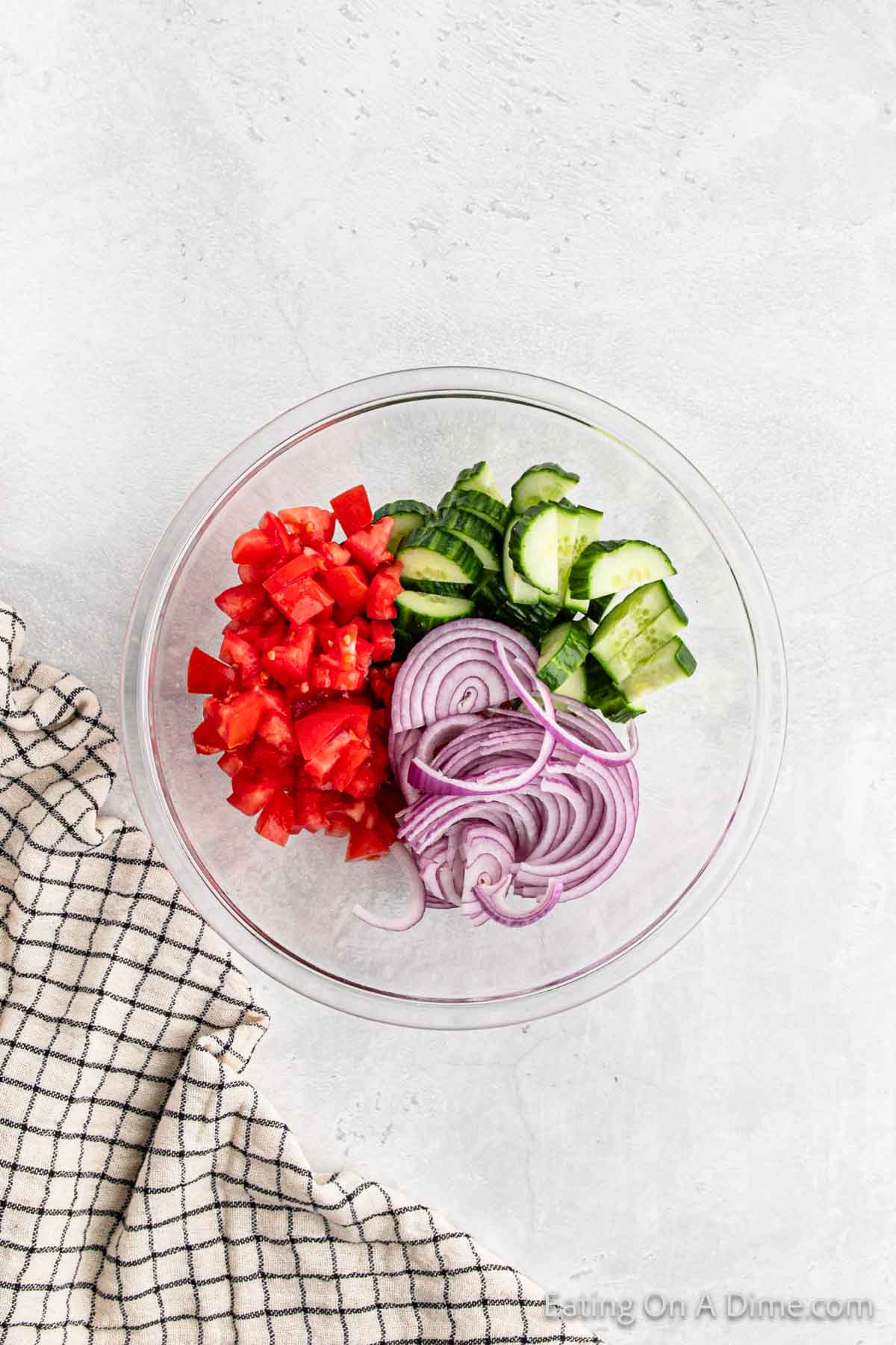 cut tomatoes, slice red onions and chopped cucumber in a bowl