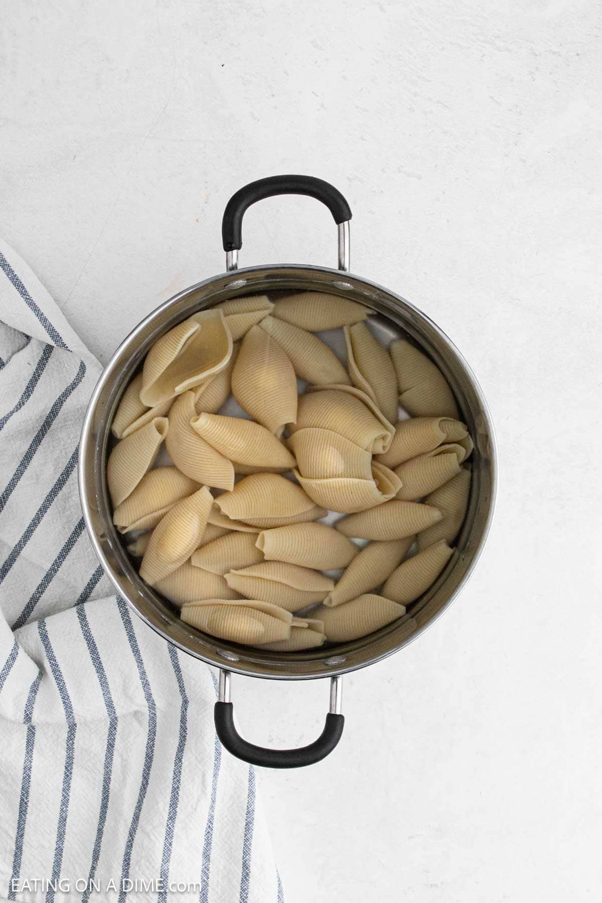 Cooked pasta shells in a large pot of water.