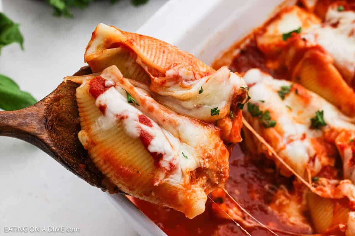 Stuffed Shells with a serving on a wooden spoon ready to serve.