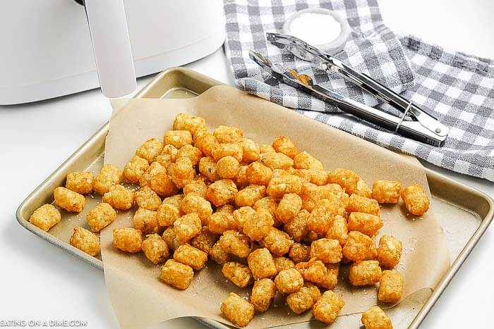 Close up image of tator tots on a cooking sheet. 
