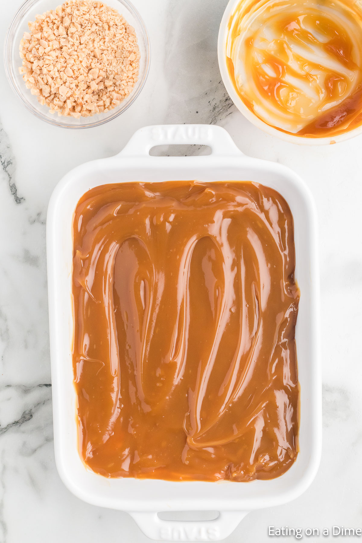Topping the cream cheese mixture with the caramel sauce