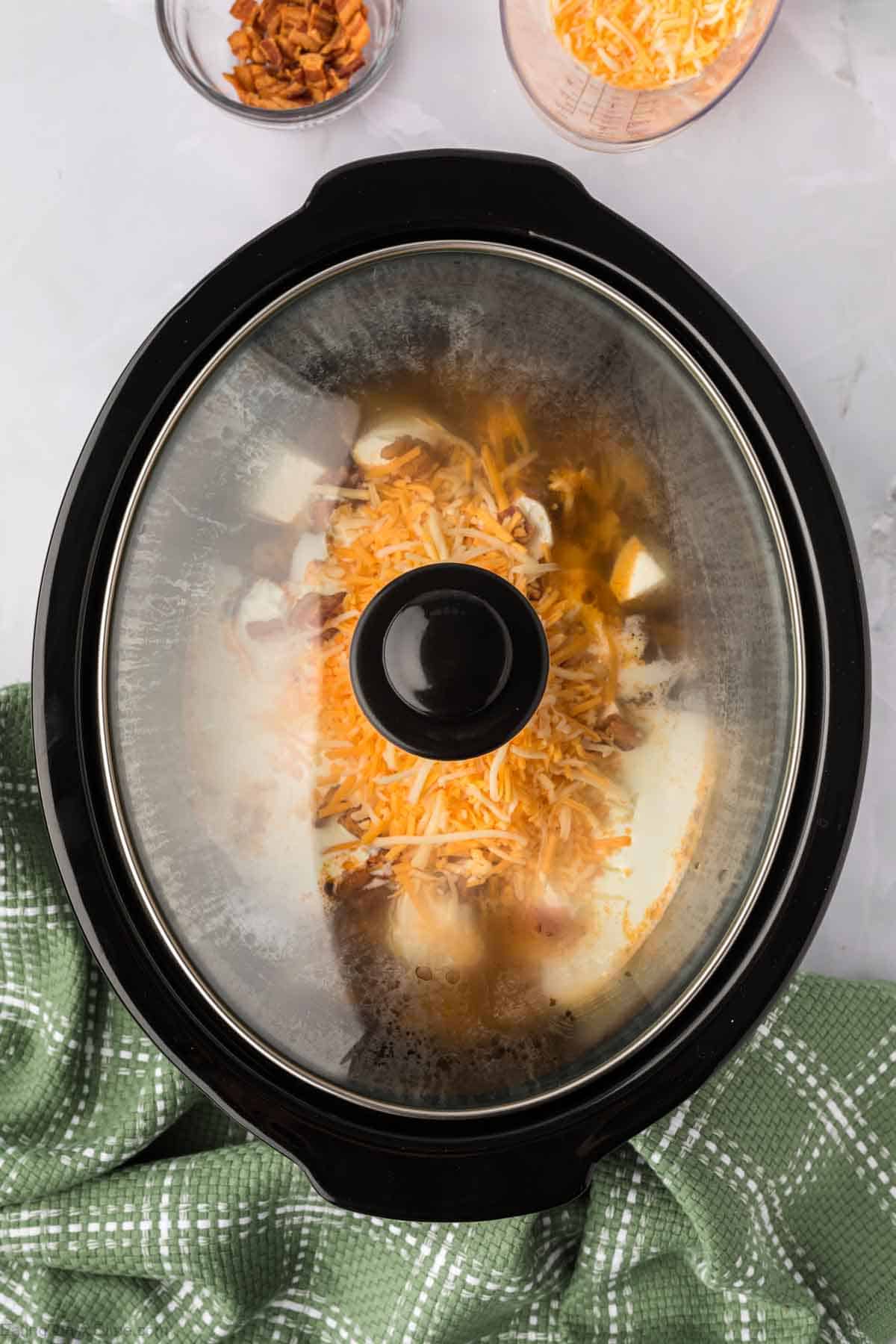 Crock pot with a lid covering the soup