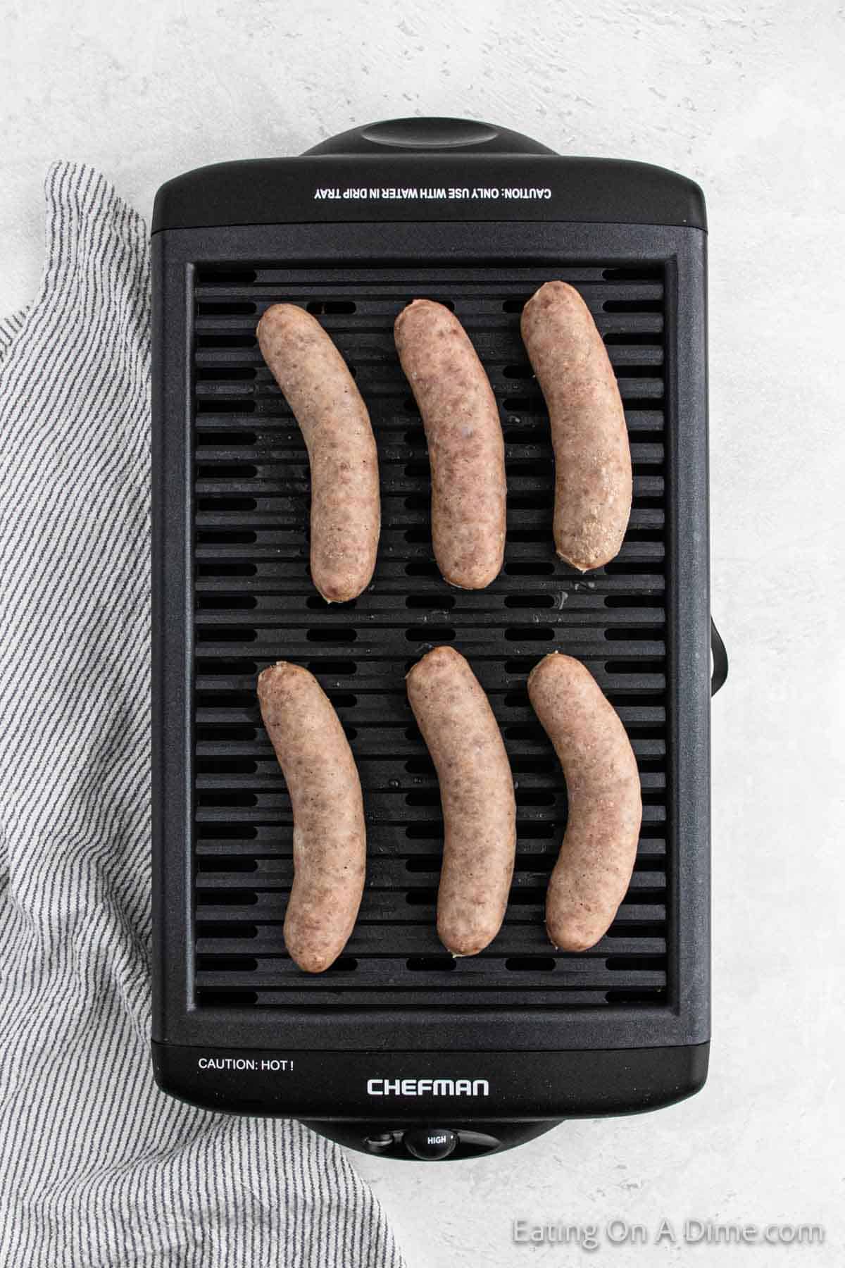 Raw brats on an indoor grill