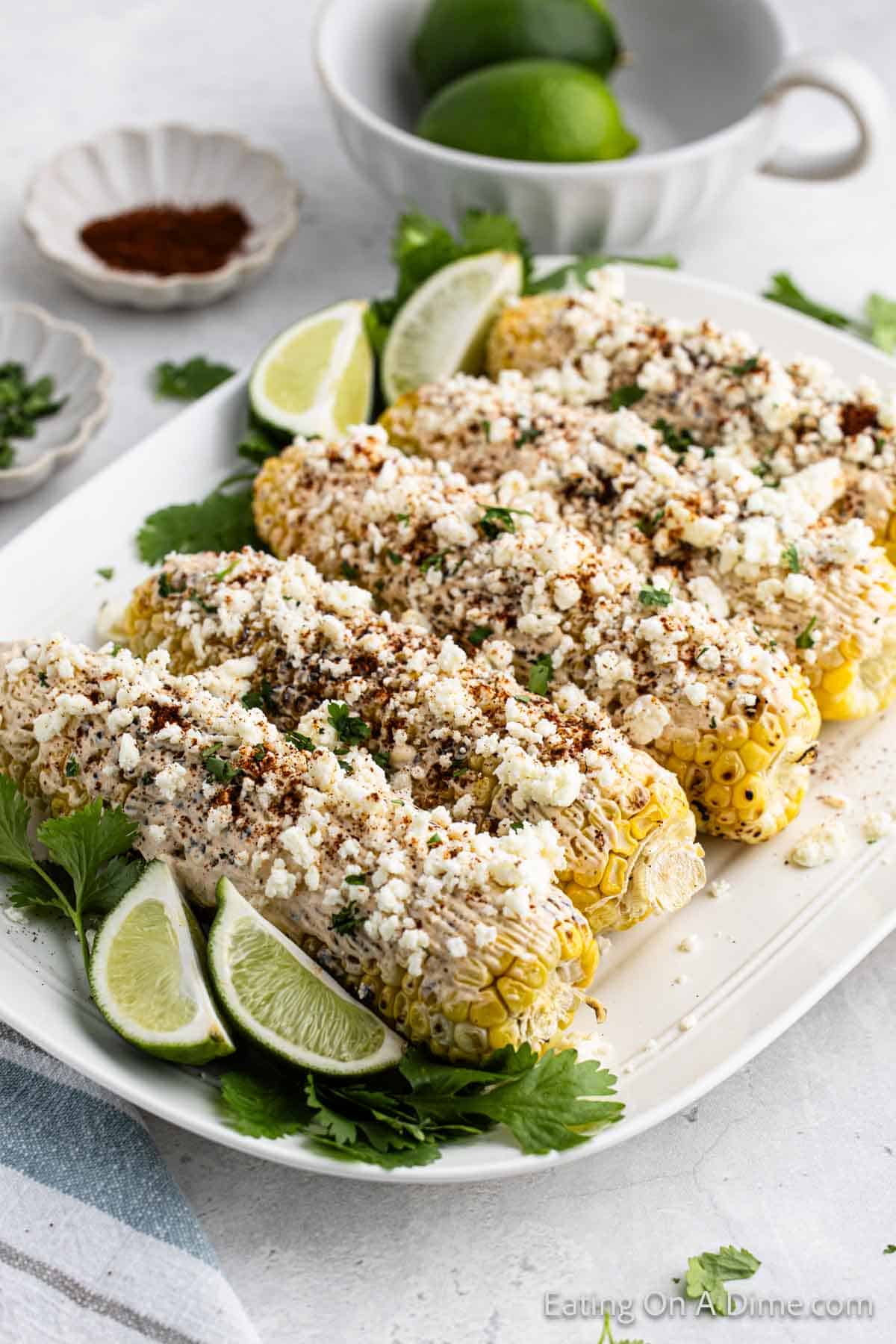 Mexican corn on the cob on a platter with fresh limes