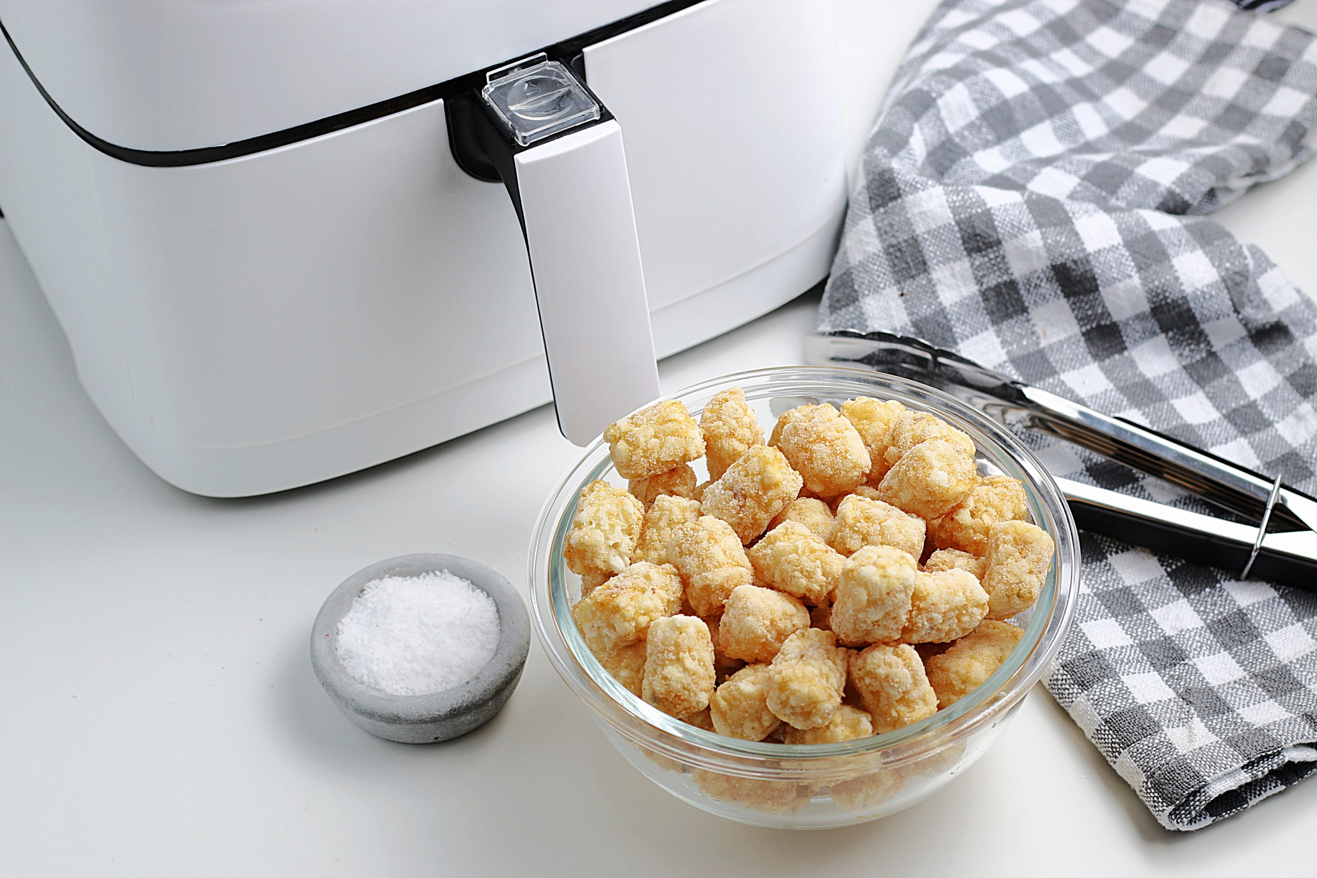 Ingredients for air fryer tator tots - frozen tator tots, cooking spray and salt. 