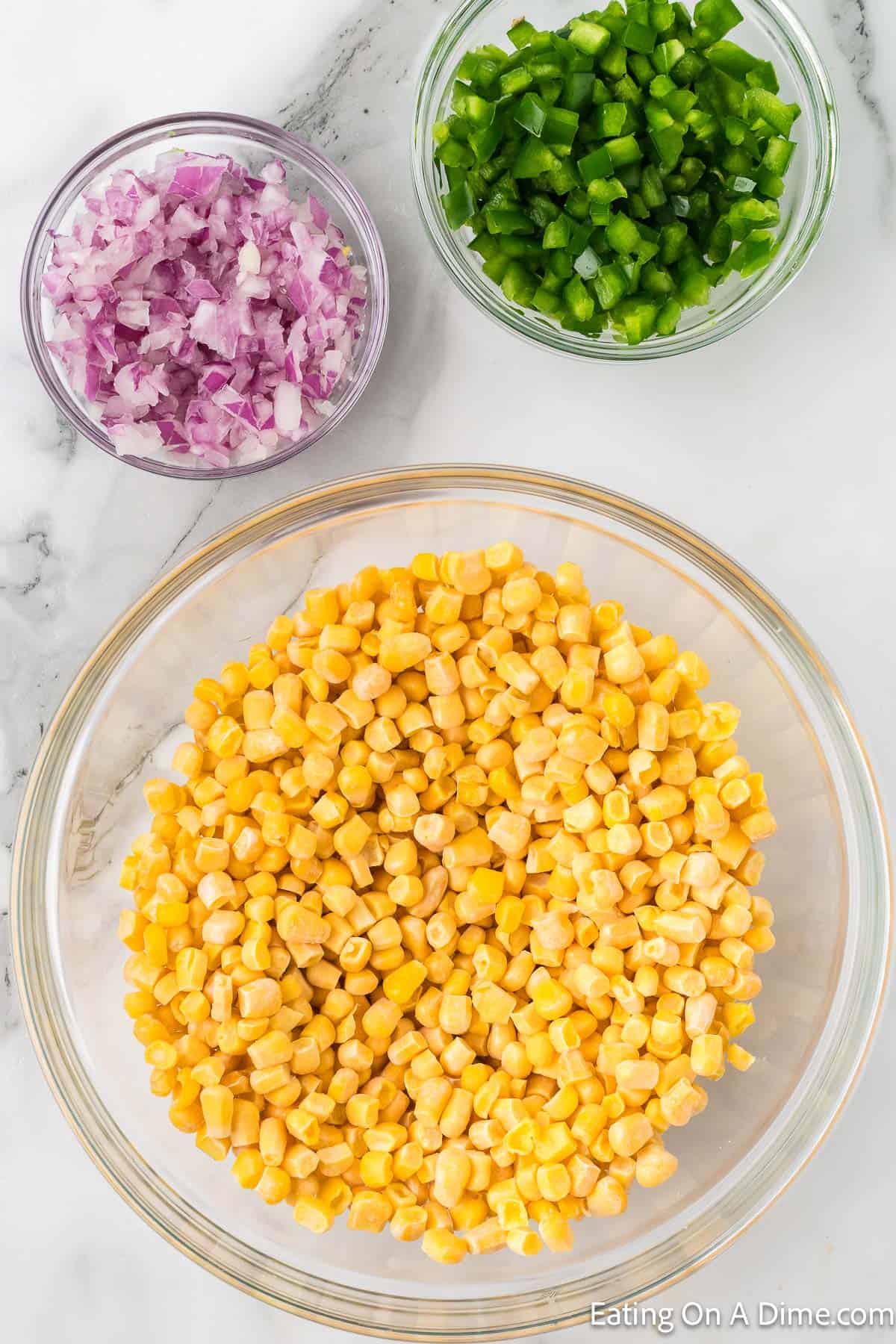 Big bowl of bowl with two small bowls of chopped red onion and bell pepper