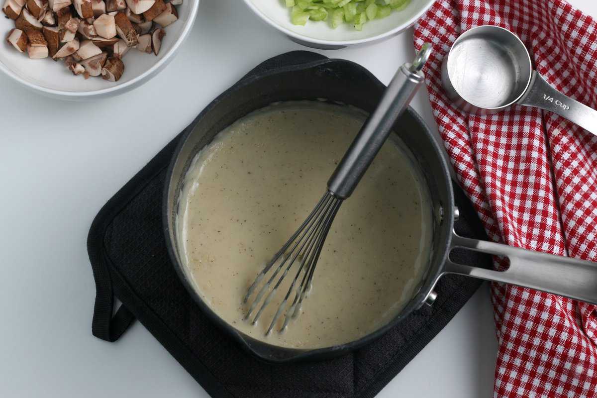 Combining the milk, butter, chicken stock in a saucepan with a whisk