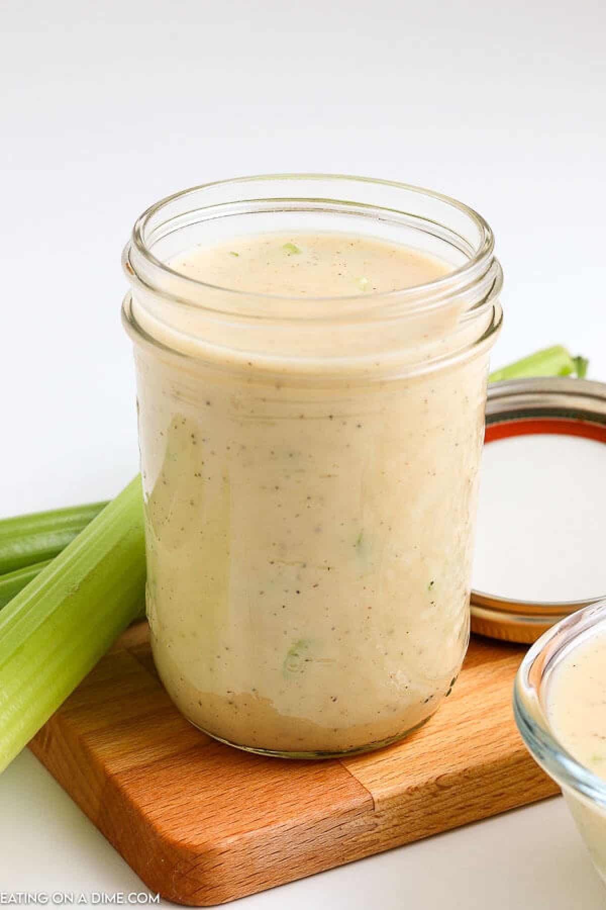 Learn how easy it is to make cream of celery soup. Save time and money and make this at home instead of buying it. Cream of celery soup in a mason jar on a small board with a side of celery stalks