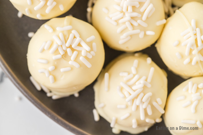 Close up White Chocolate Truffles lined out on a gray plate 