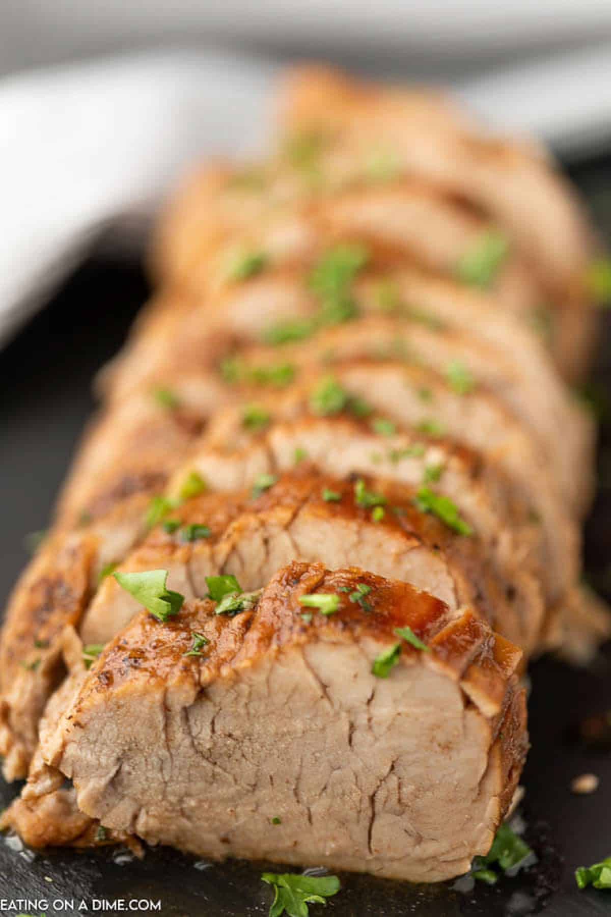 Slice pork tenderloin on a platter