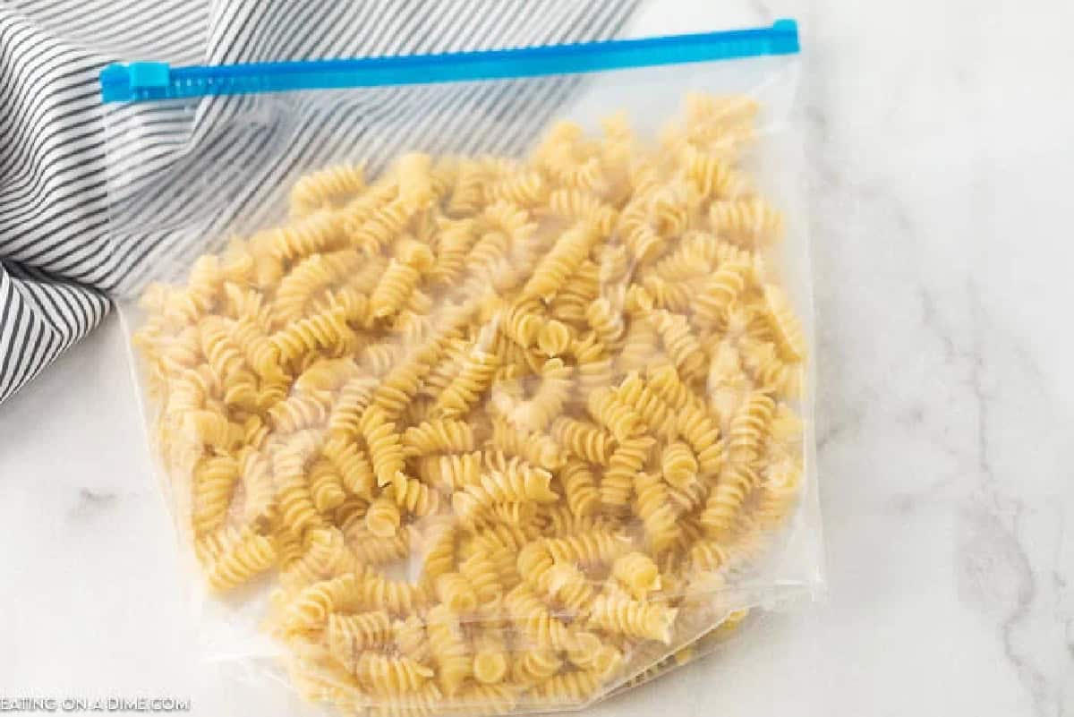 Cooked rotini pasta in a large freezer bag, sealed with the air removed.