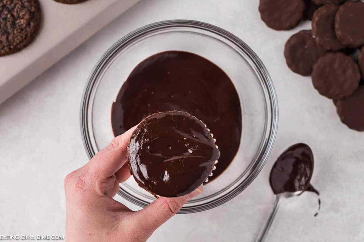 Dipped cupcakes in the chocolate ganache in a bowl