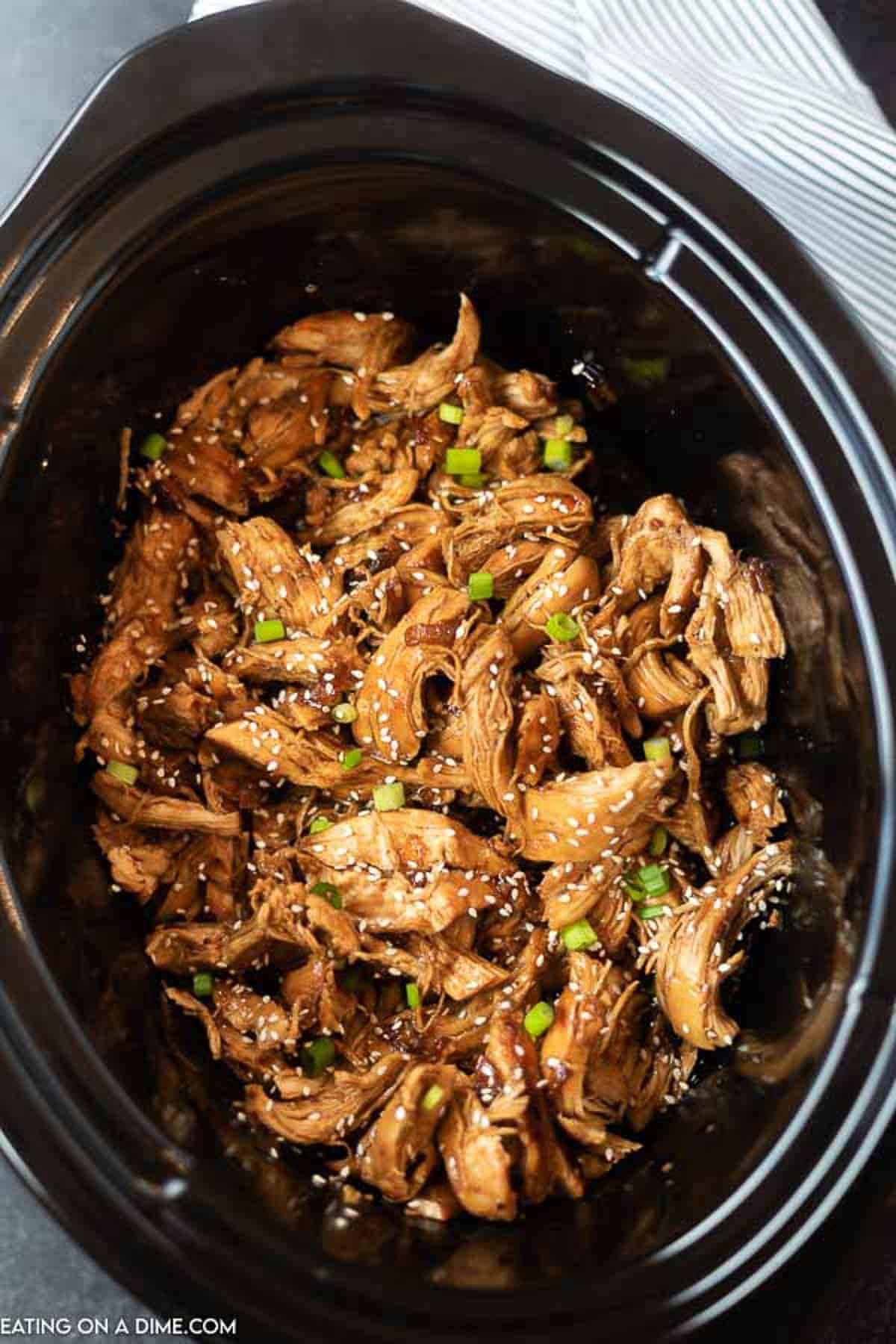 Teriyaki Chicken in the slow cooker topped with sesame seeds and green onions