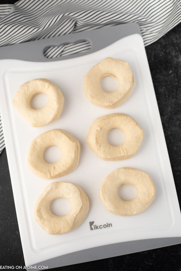 Close up image of donuts on a cutting board before being put in the air fryer. 