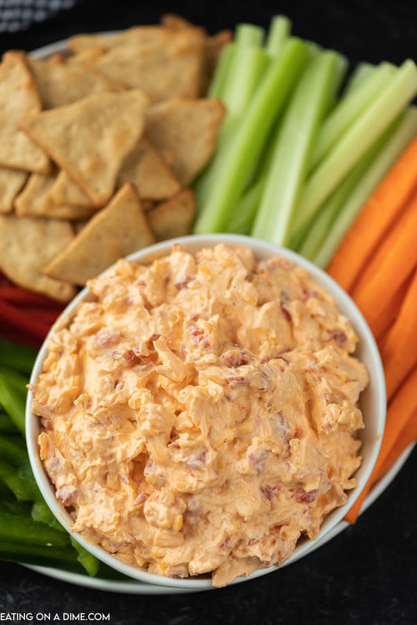 pimento cheese in a bowl with veggies around it