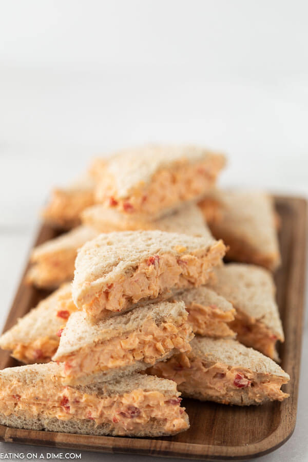Small Tea Pimento Cheese Sandwiches on a wooden platter 