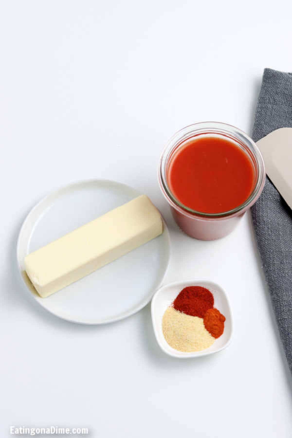 Ingredients to make easy homemade  buffalo sauce: hot sauce, unsalted butter, garlic powder, paprika and cayenne pepper 