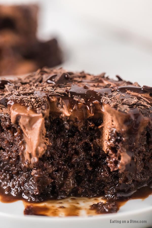 Slice of chocolate poke cake on plate.