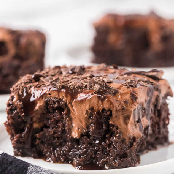 Slice of chocolate poke cake on plate.