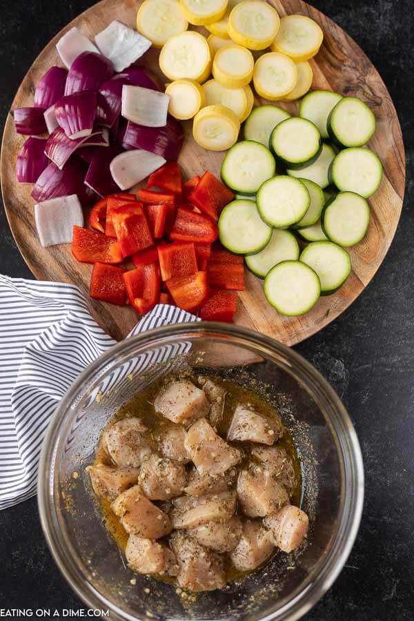 picture of ingredients- diced vegetables and chicken in a bowl with marinade.