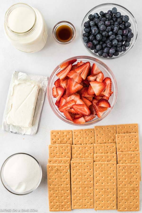 Picture of ingredients: heavy whipping cream, vanilla, cream cheese, sugar, graham crackers, blueberries, strawberries. 