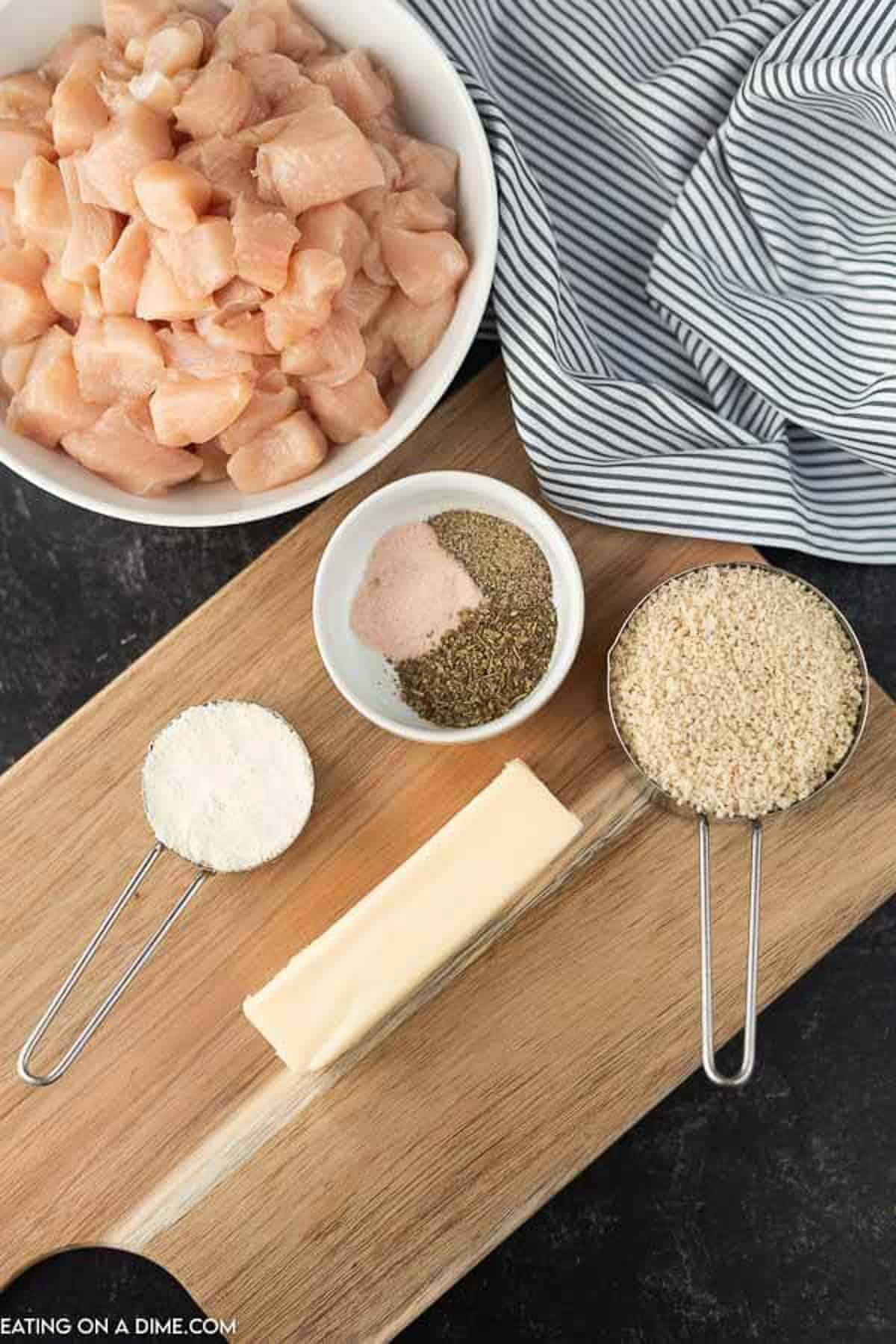 Ingredients needed to make air fryer chicken nuggets: chicken breasts, Italian Seasoning, salt and pepper, bread crumbs, parmesan cheese and butter. 