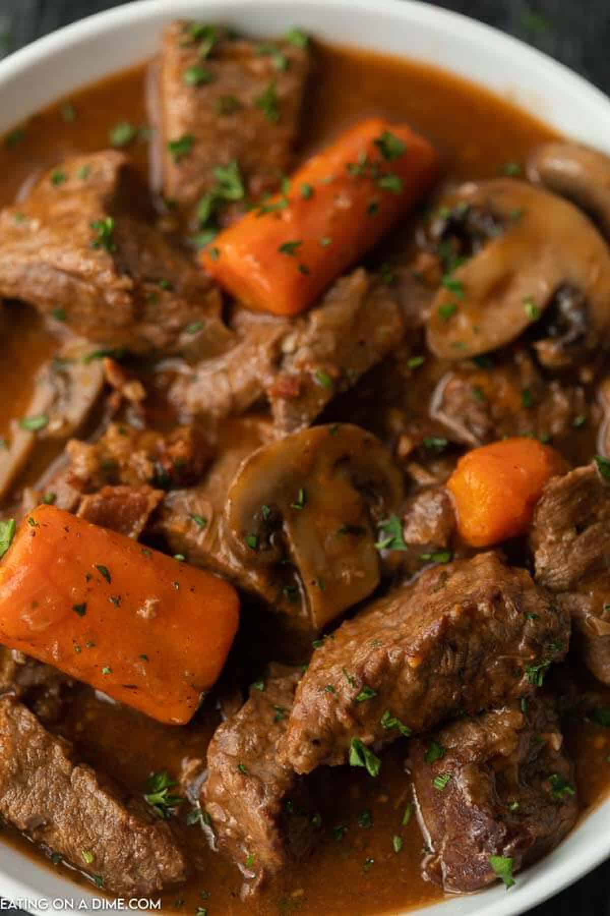 Slow cooker beef bourguignon in a white bowl