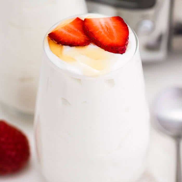 photo of yogurt in a glass with fruit.