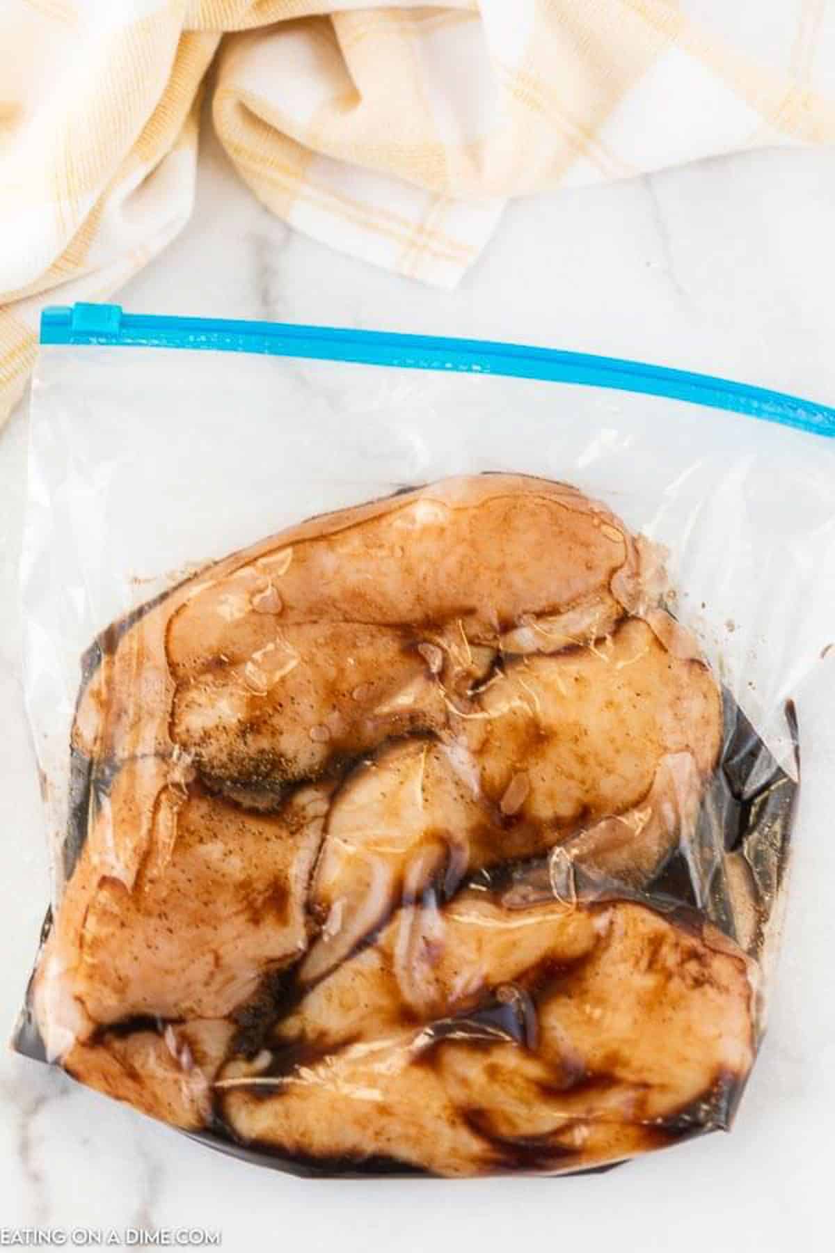The chicken breasts marinading in a freezer bag with the marinade ingredients.  