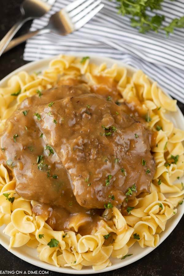 plate of egg noodles and cube steak and gravy on a white plate