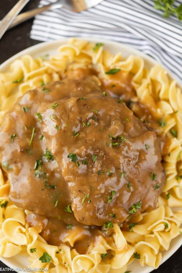plate of egg noodles with cube steak and gravy on top