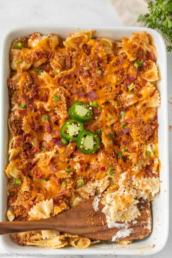 Close up image of a 9x13 pan of Jalapeno Popper Chicken Casserole with a brown spoon. 
