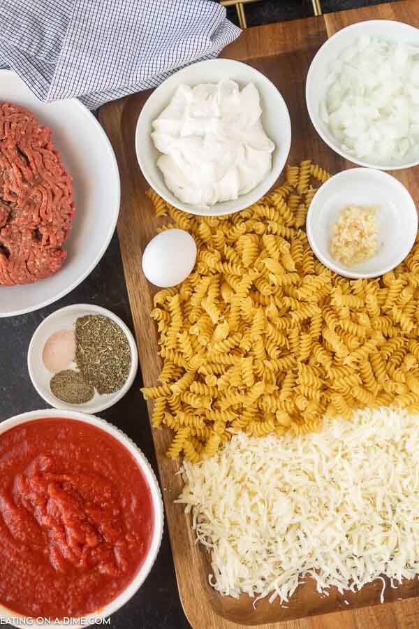 ingredients for casserole: ground beef, cheese, seasoning, egg, pasta, tomatoes
