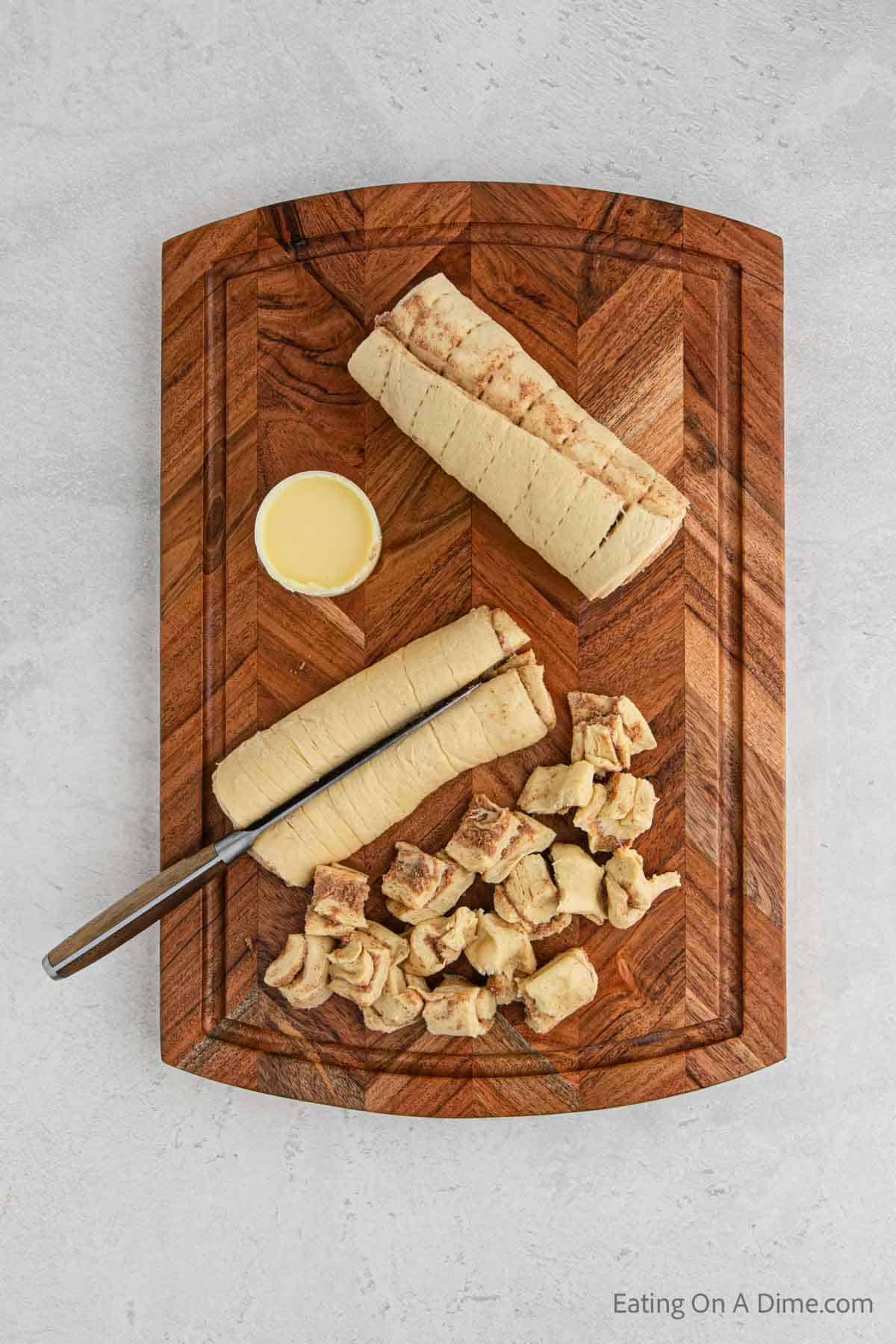 Cutting the cinnamon roll pieces on a cutting board