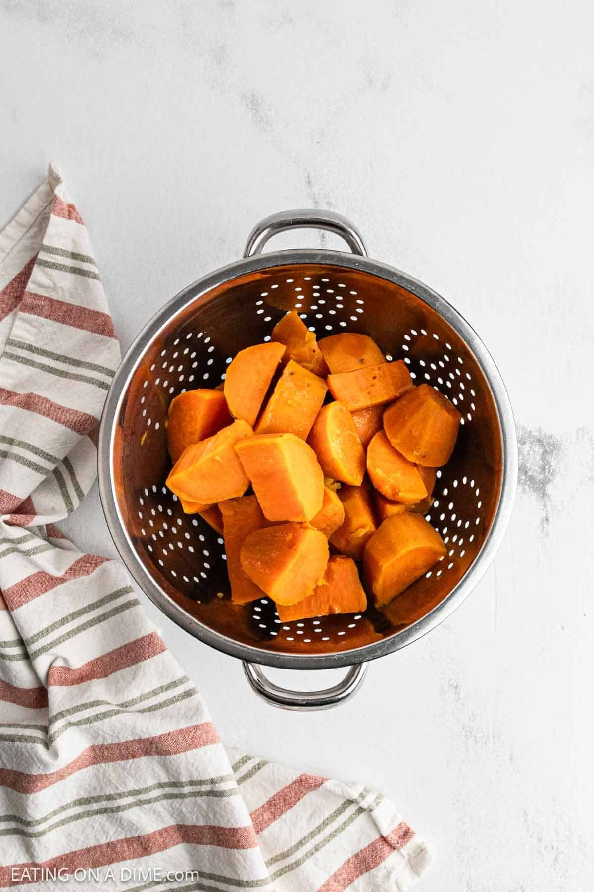 Cooked sweet potatoes in a colander.
