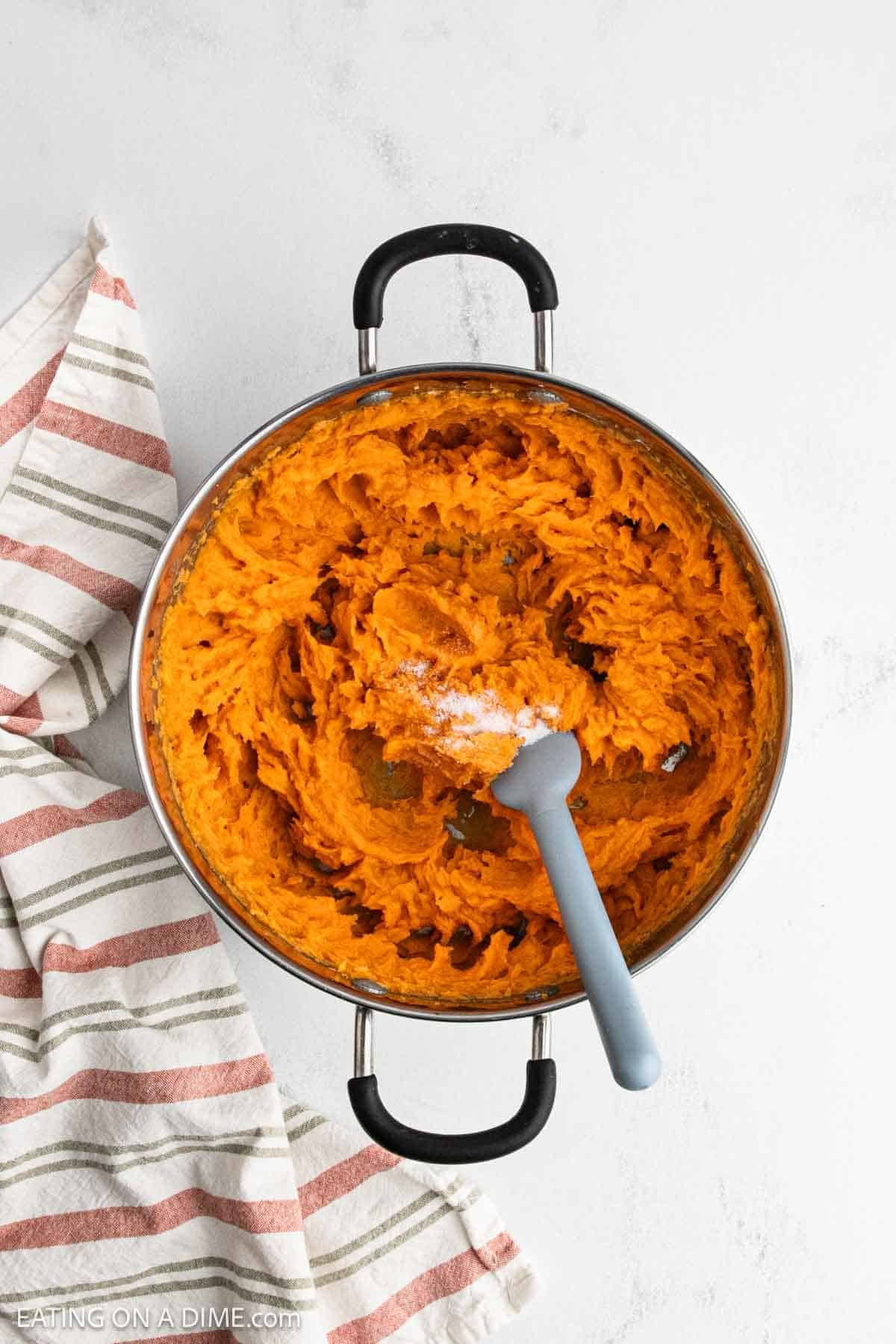 Recipe in a large pot topped with salt ready to mix in.