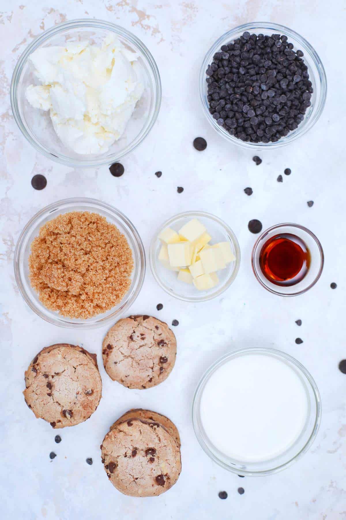 Ingredients needed to make this recipe includes chocolate chip cookies, butter, cream cheese, heavy whipping cream, vanilla extract, brown sugar, mini chocolate chips and jars.