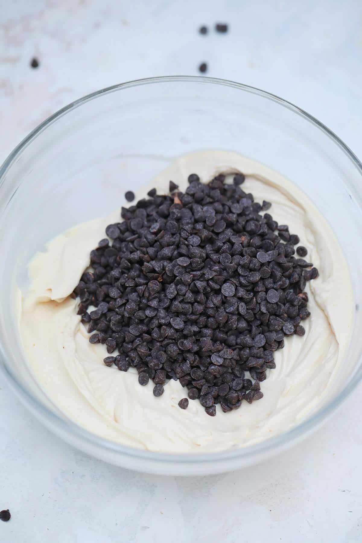 Chocolate chips topped the cream cheese mixture in a bowl.