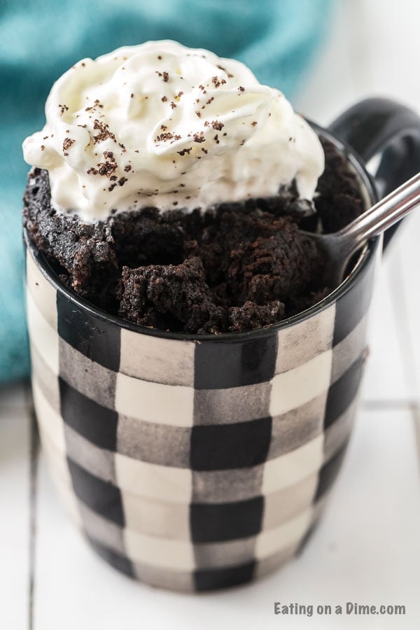 mug cake with spoon and topped with whipped cream