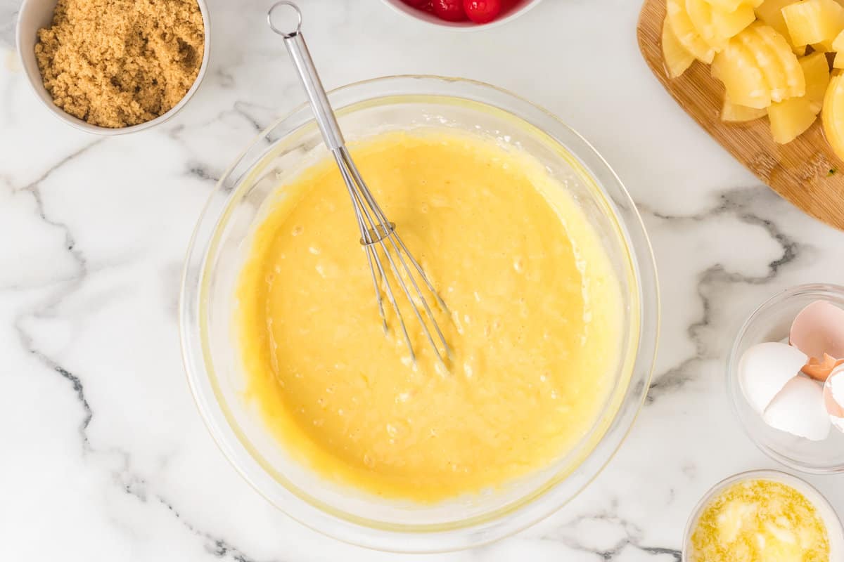 Combining the cake mix, pineapple juice, oil and eggs in a mixing bow